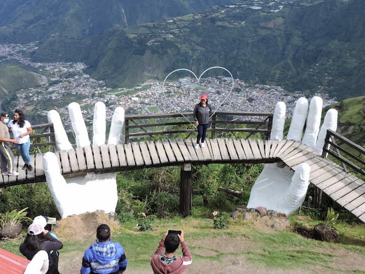 Frente a Baños hay un columpio y las manos de dios